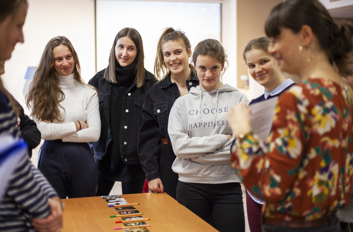 Cinq jeunes femmes écoutent une femme plus âgée en souriant